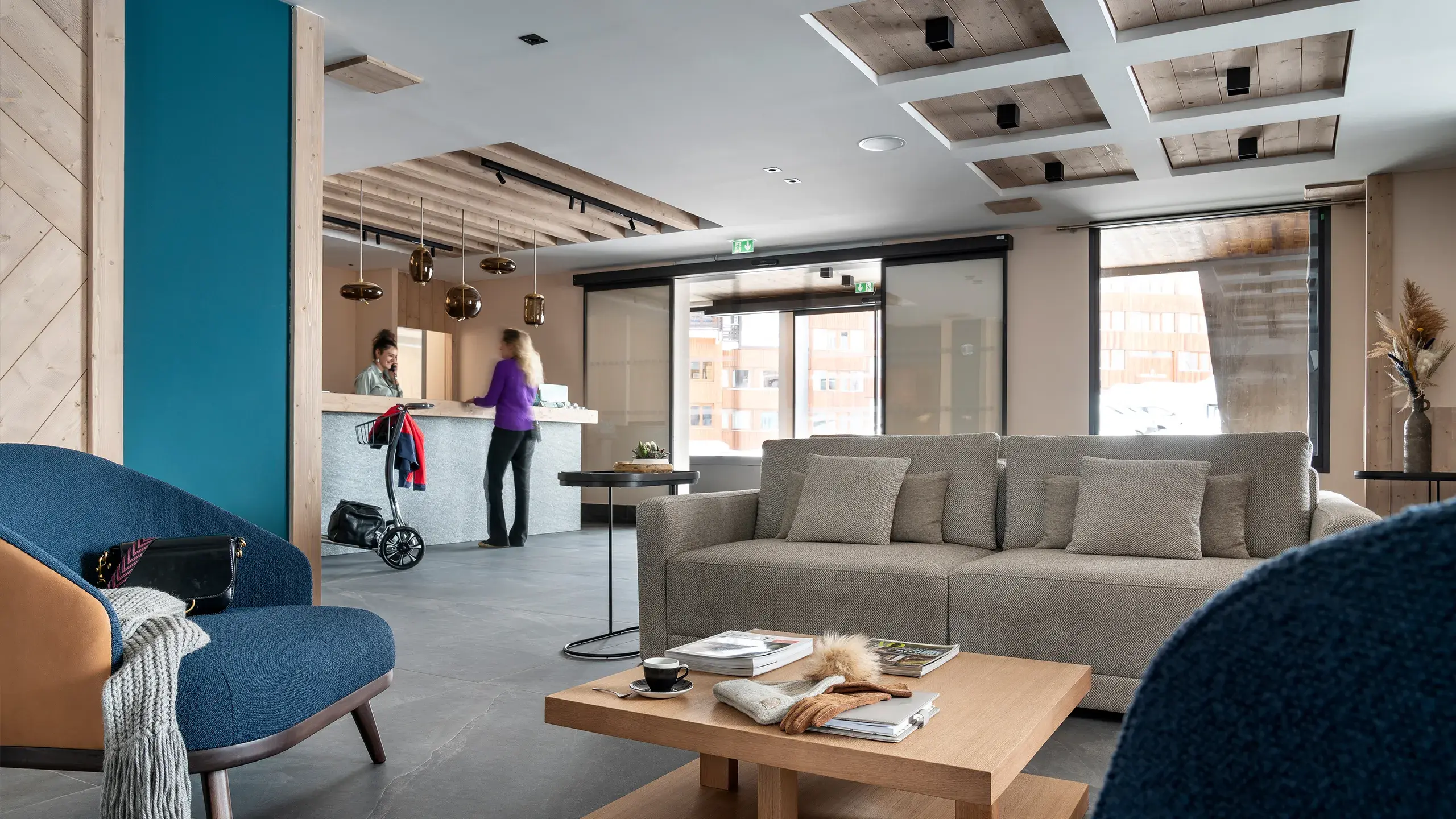 Des personnes sont au comptoir de la réception de la résidence Manaka à La Plagne