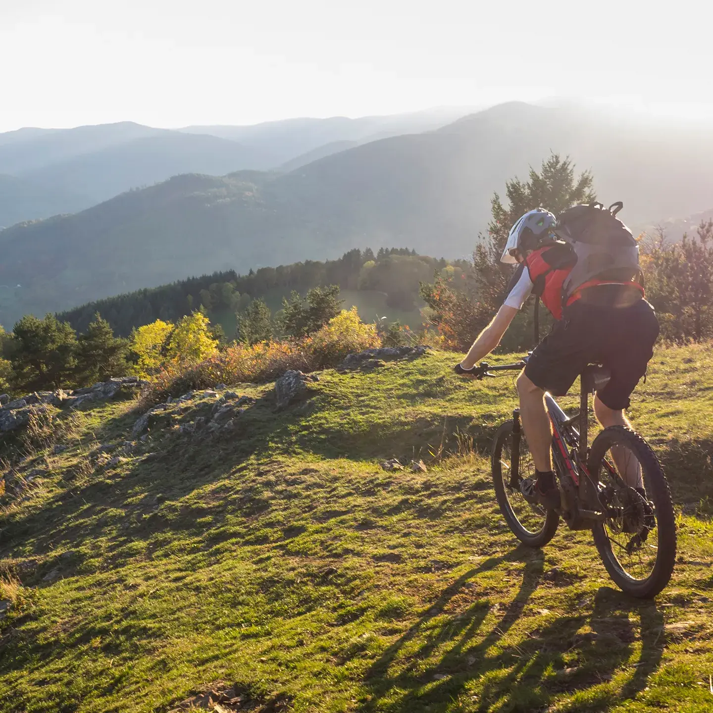 Un homme pratique du VTT, au coucher du soleil
