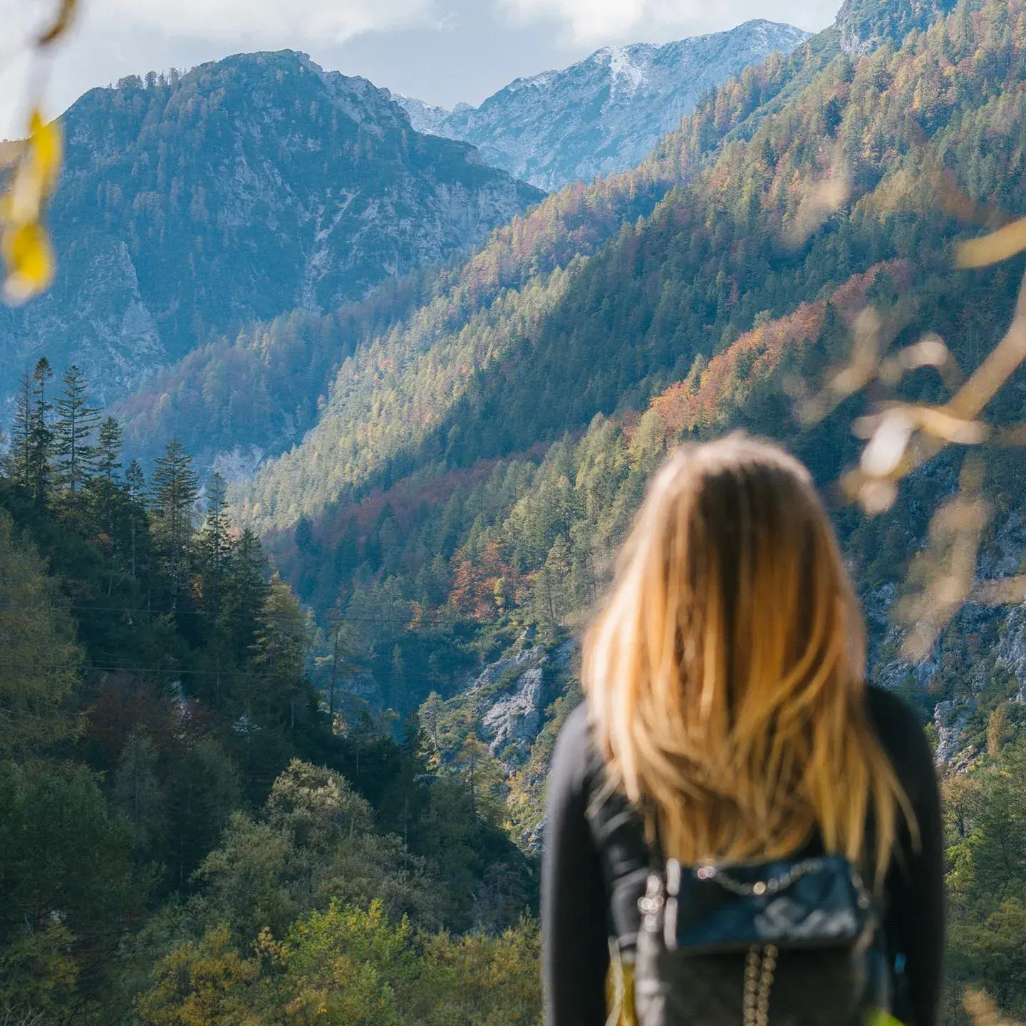 Une femme admire la vue depuis le sommet d'une montagne
