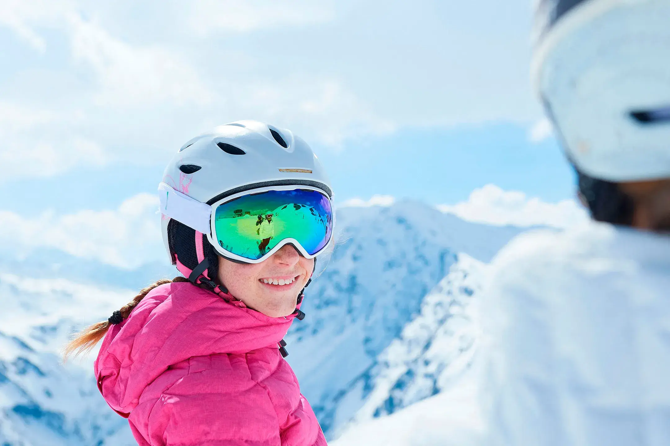 enfant avec équipement de ski face à un paysage enneigé 