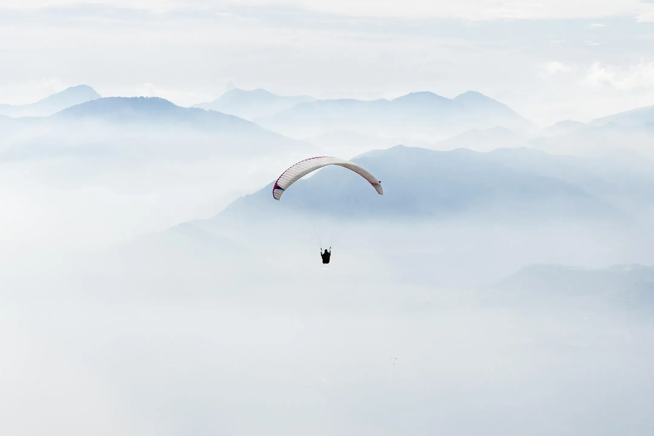 Un parapentiste plane au milieu des nuages