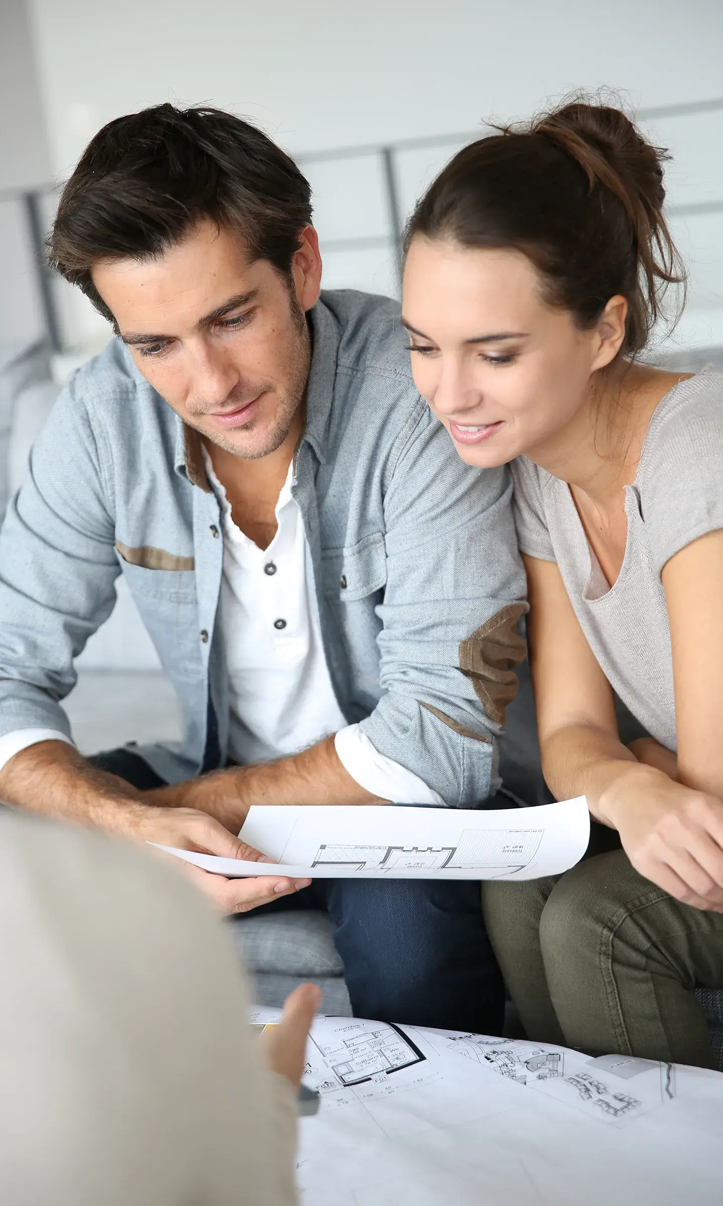 Un couple est en train de regarder des plans d'un appartement en vue d'un achat immobilier