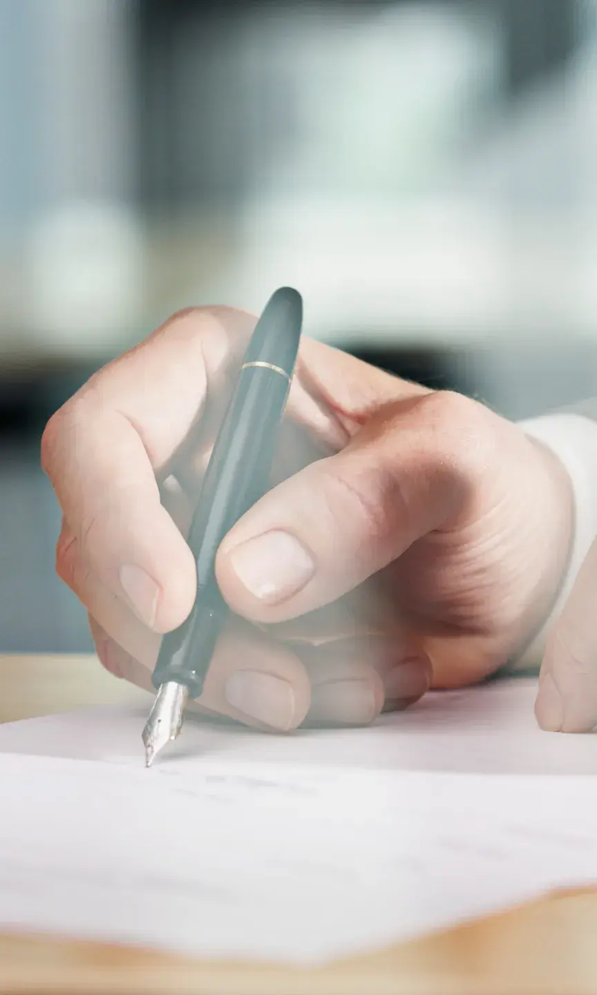 Un homme est en train de signer un document officiel chez le notaire 