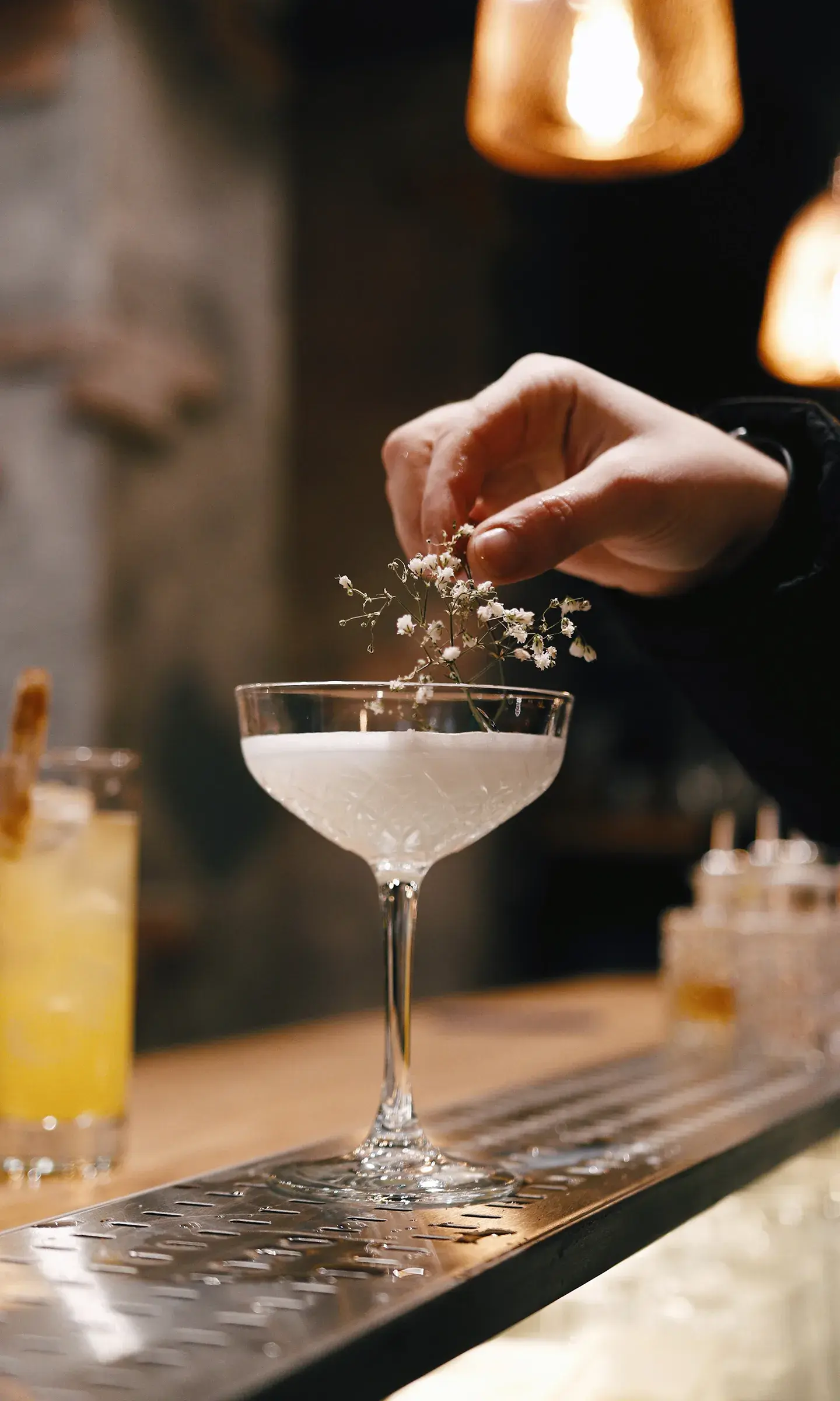 Une personne est en train de soulever une branche fleurie d'un cocktail