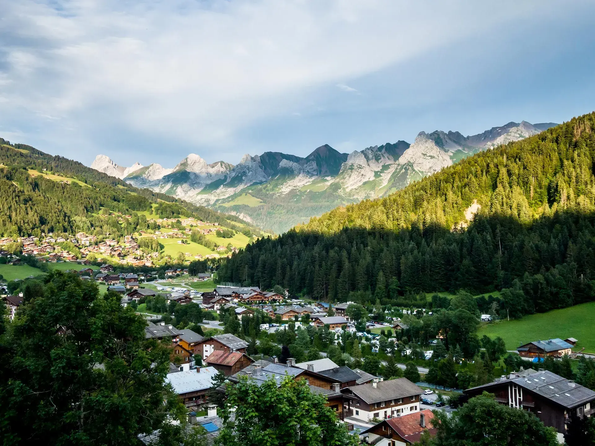 Vue sur le village du Grand-Bornand en été avec la chaine des Aravis en arrière plan