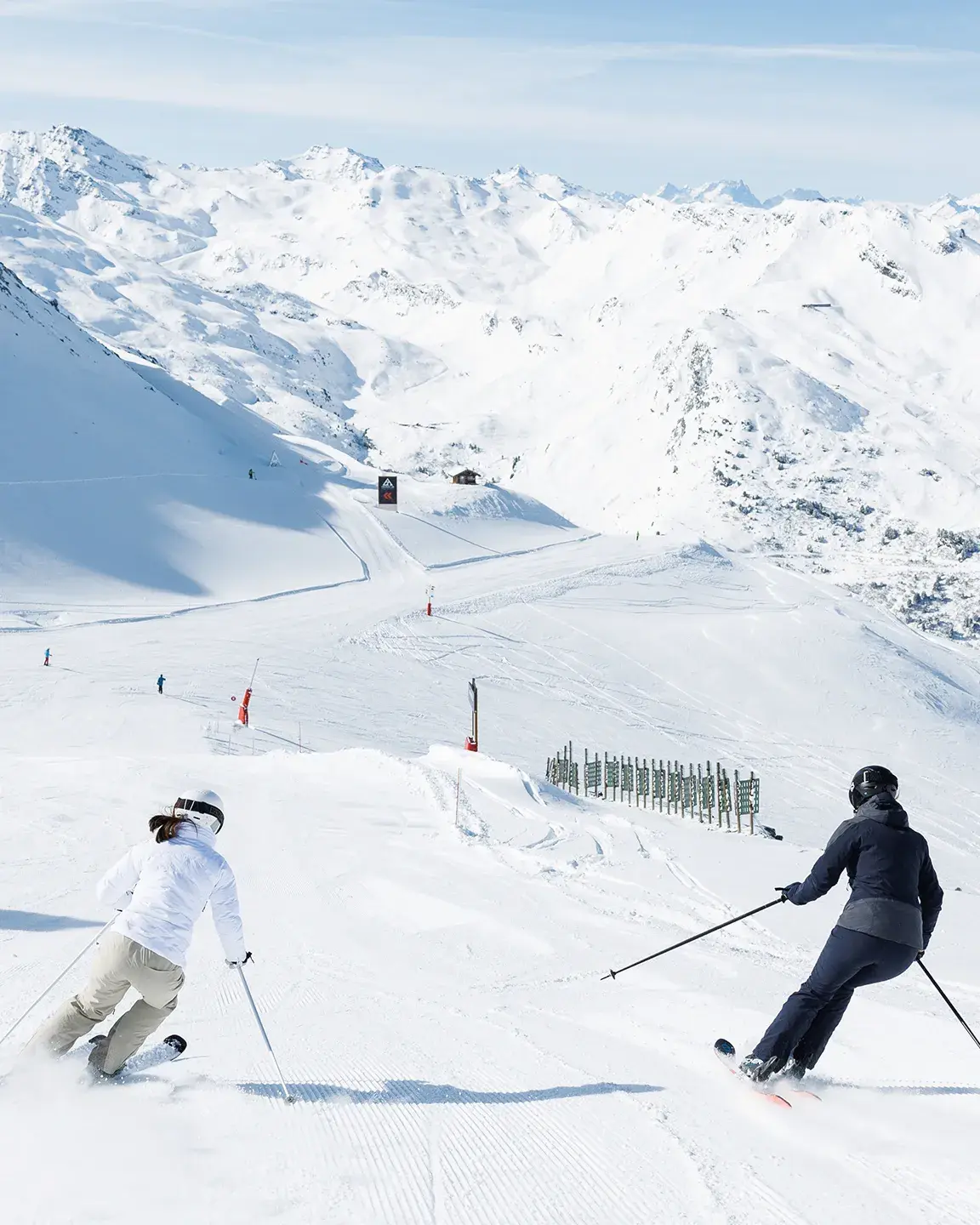 Deux personnes dévalent les pistes de Méribel en ski alpin