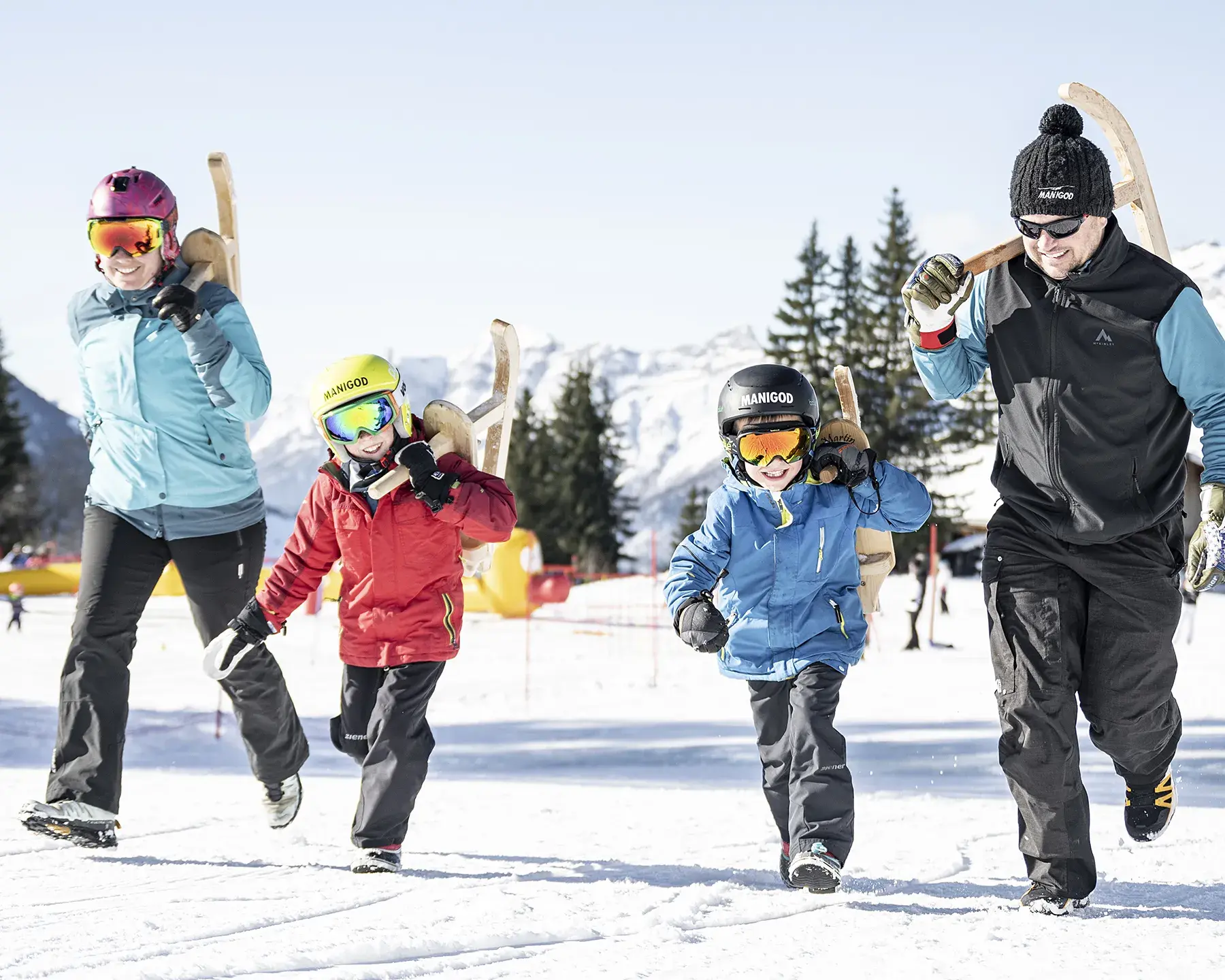 Une famille marche sur une piste du Grand-Bornand, leurs parets à la main