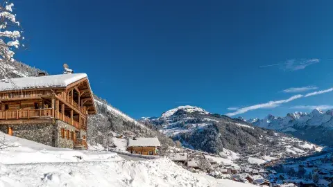 La Ferme de Juliette au Grand-Bornand, façade extérieure du chalet de prestige avec panorama sur les sommets enneigés